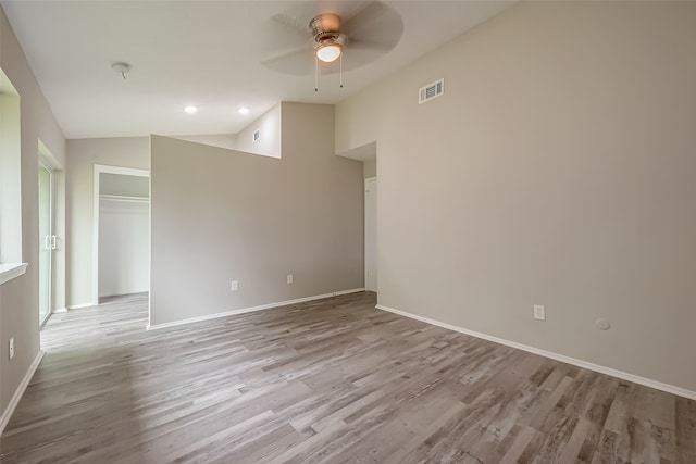 empty room featuring lofted ceiling, light hardwood / wood-style flooring, and ceiling fan