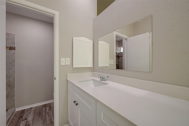 bathroom with a shower, wood-type flooring, and vanity