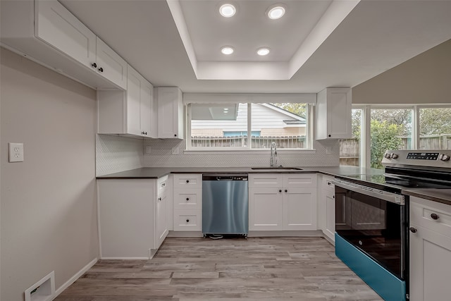 kitchen with stainless steel appliances, sink, light wood-type flooring, and white cabinets