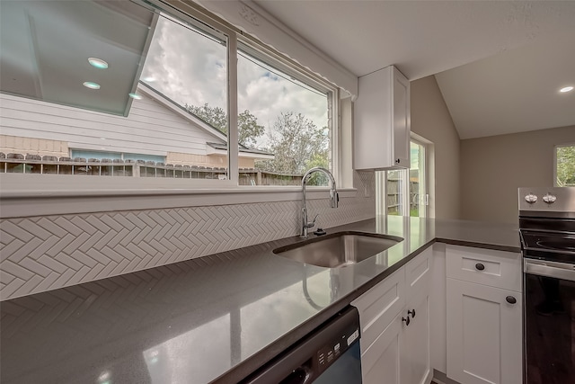 kitchen featuring black electric range, white cabinets, vaulted ceiling, and sink