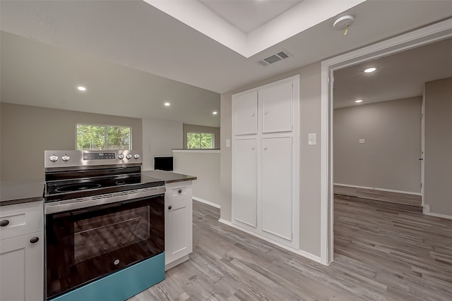 kitchen featuring electric range, white cabinetry, and light hardwood / wood-style floors