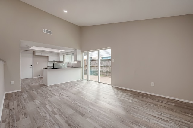 unfurnished living room with light wood-type flooring and sink