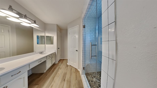 bathroom with walk in shower, vanity, and hardwood / wood-style flooring