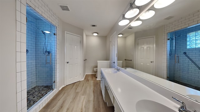 bathroom featuring walk in shower, wood-type flooring, vanity, and toilet