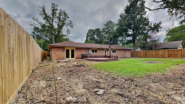 rear view of house featuring a deck and a yard