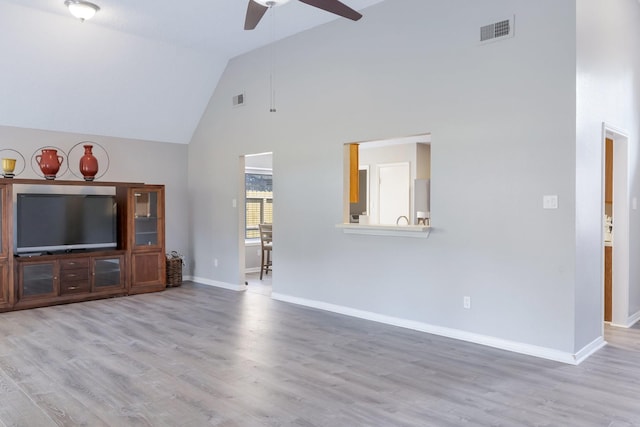 unfurnished living room with ceiling fan, light hardwood / wood-style floors, and high vaulted ceiling