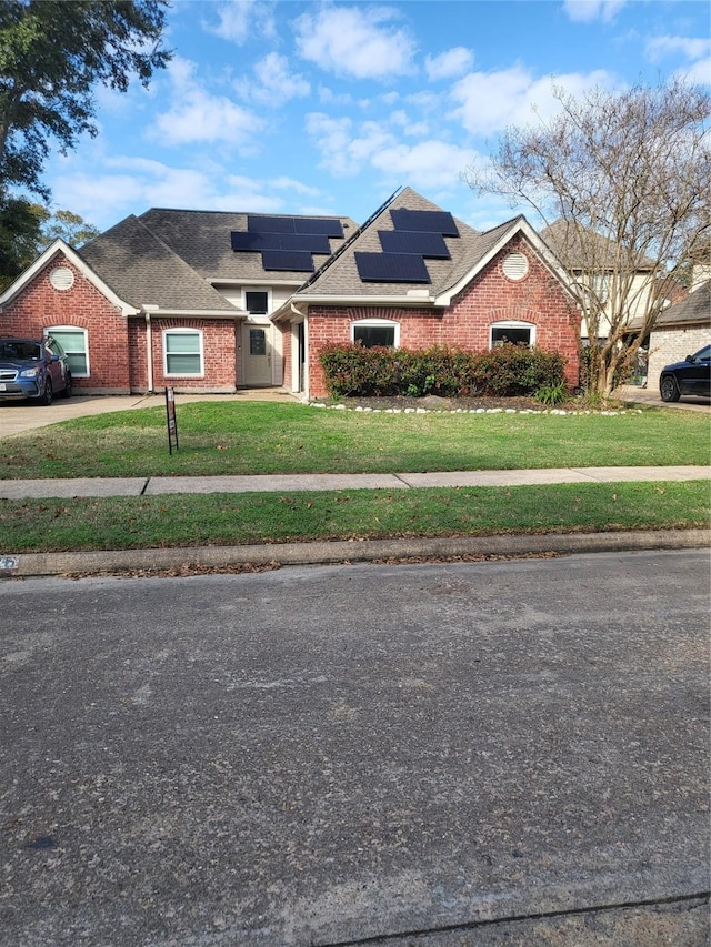 view of front of house with solar panels, a garage, and a front lawn