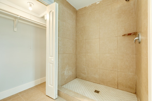 bathroom with tiled shower and tile patterned floors