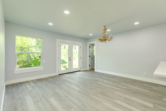 empty room with light wood-type flooring and french doors