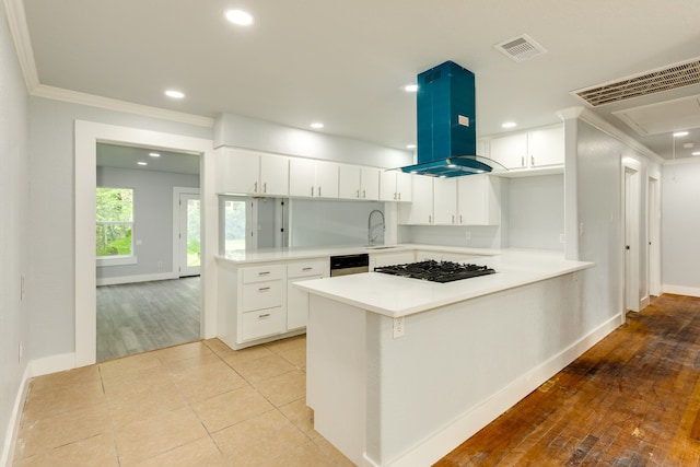 kitchen featuring white cabinets, light hardwood / wood-style flooring, sink, kitchen peninsula, and island range hood