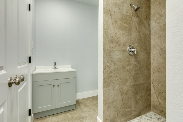 bathroom with vanity and a tile shower