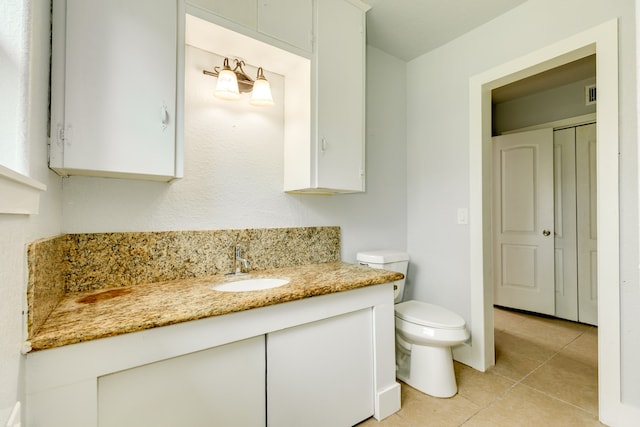 bathroom with vanity, toilet, and tile patterned flooring