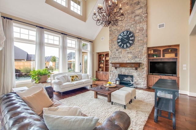 living room featuring high vaulted ceiling, a notable chandelier, a stone fireplace, and a healthy amount of sunlight