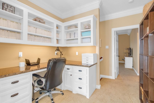 carpeted office with ornamental molding and built in desk