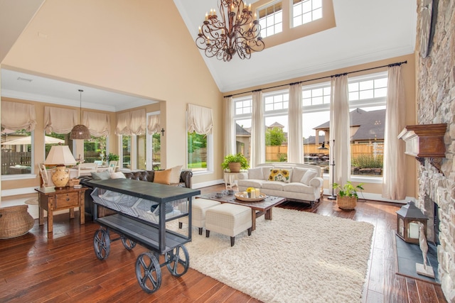 sunroom featuring plenty of natural light, vaulted ceiling, a notable chandelier, and a fireplace