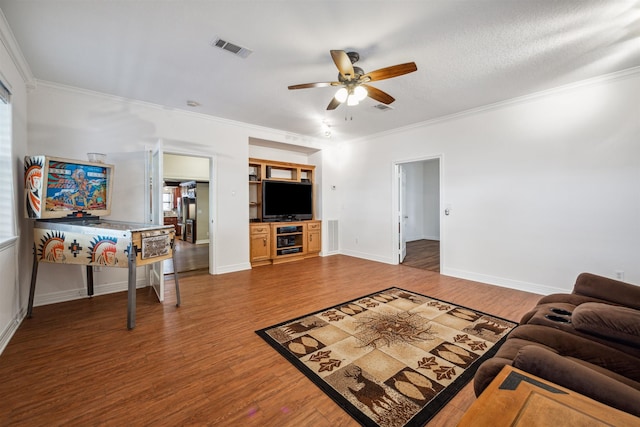 living room featuring ceiling fan, ornamental molding, and hardwood / wood-style flooring