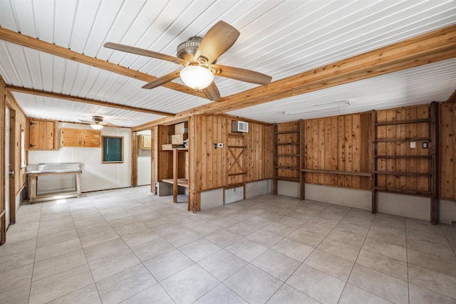 unfurnished room featuring ceiling fan, beamed ceiling, wooden walls, and light tile patterned flooring