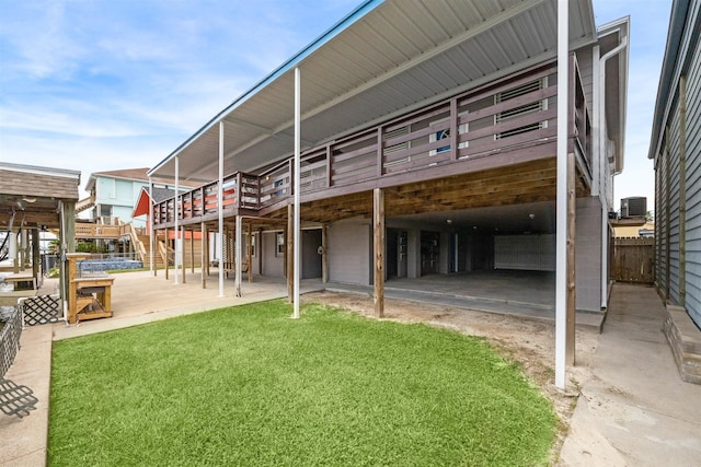 rear view of house featuring a lawn and cooling unit