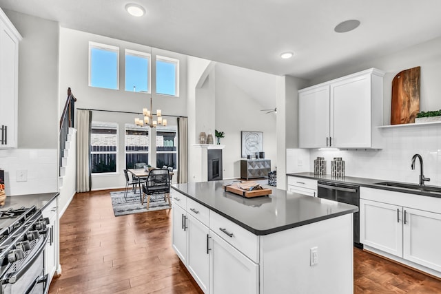 kitchen with sink, stainless steel appliances, a high ceiling, white cabinets, and dark wood-type flooring