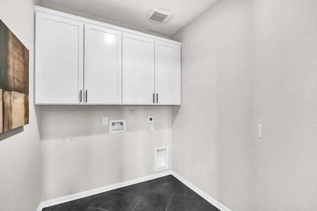 washroom featuring dark tile patterned floors, hookup for a gas dryer, washer hookup, hookup for an electric dryer, and cabinets