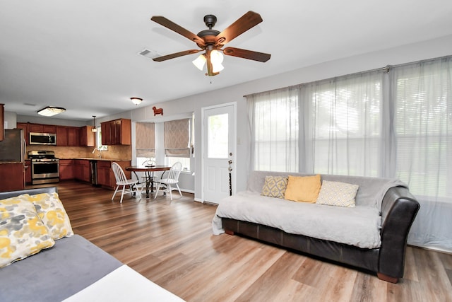 living room with dark hardwood / wood-style flooring, ceiling fan, and sink