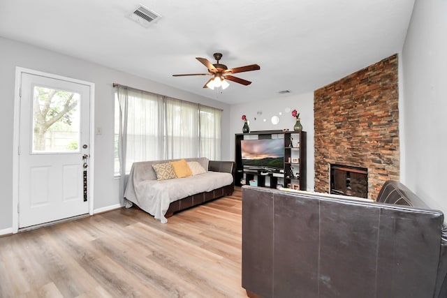 living room featuring a fireplace, hardwood / wood-style floors, and ceiling fan