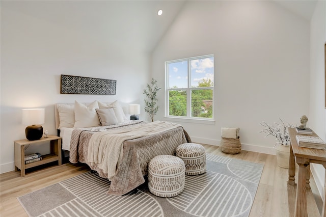 bedroom featuring light hardwood / wood-style flooring and high vaulted ceiling