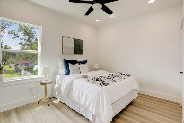 bedroom featuring multiple windows, light wood-type flooring, and ceiling fan