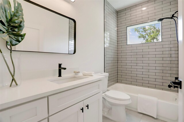 full bathroom featuring vanity, tiled shower / bath, toilet, and tile patterned floors