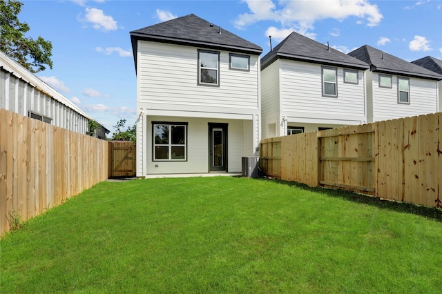 rear view of property featuring a yard and central AC