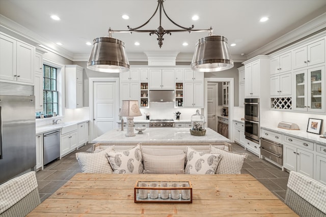 kitchen featuring crown molding, white cabinetry, decorative light fixtures, decorative backsplash, and appliances with stainless steel finishes