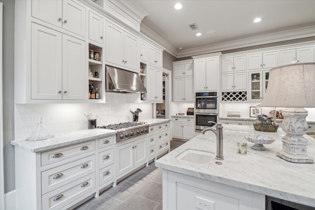 kitchen featuring white cabinets, crown molding, appliances with stainless steel finishes, sink, and wall chimney range hood