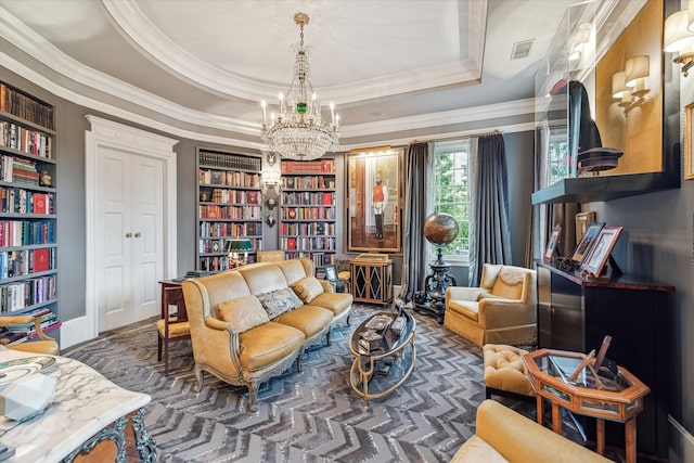 sitting room with a tray ceiling, crown molding, and a notable chandelier