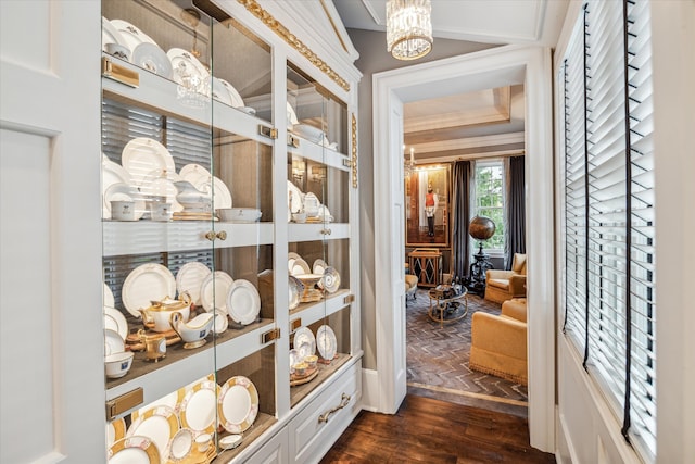 hall featuring a chandelier, dark hardwood / wood-style flooring, and crown molding