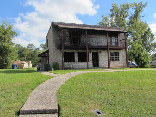 view of front of property with a front yard and central AC unit