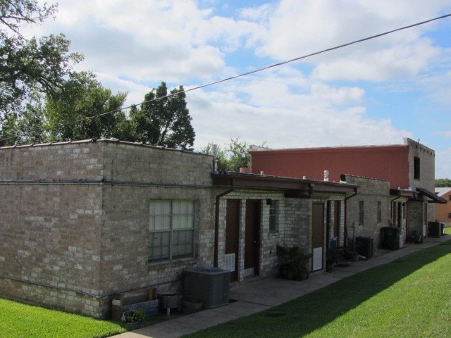 rear view of house featuring a yard and central AC unit