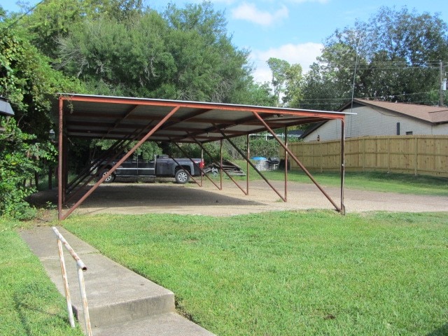 view of vehicle parking with a lawn and a carport