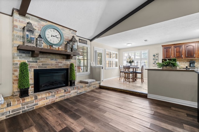 unfurnished living room with a brick fireplace, a textured ceiling, hardwood / wood-style floors, and vaulted ceiling