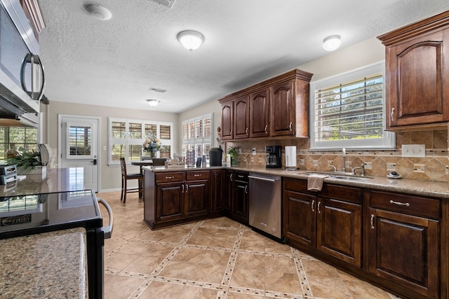 kitchen featuring appliances with stainless steel finishes, a healthy amount of sunlight, and backsplash