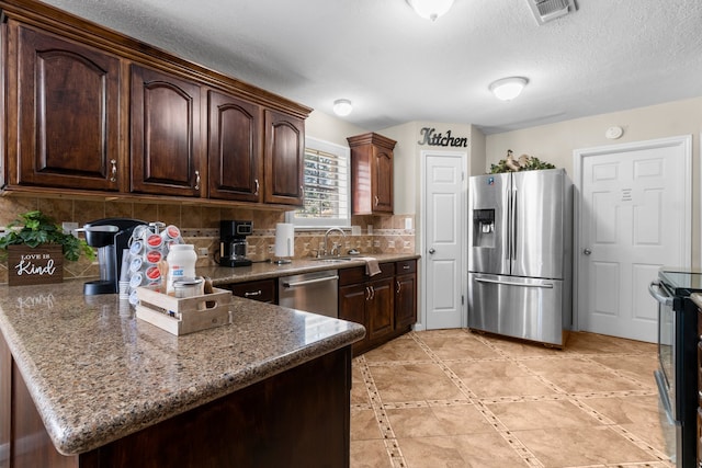 kitchen featuring dark brown cabinets, backsplash, and appliances with stainless steel finishes