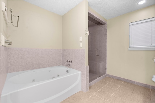 bathroom with a textured ceiling, independent shower and bath, and tile patterned floors