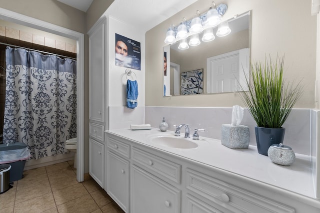 bathroom featuring tile patterned flooring, vanity, and toilet