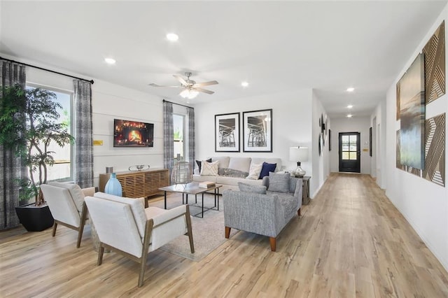 living room with light wood-type flooring and ceiling fan