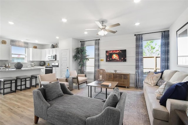 living room with ceiling fan and light wood-type flooring