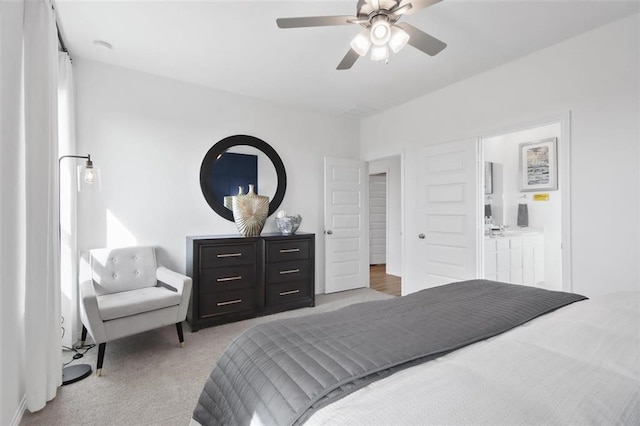 bedroom featuring ceiling fan, connected bathroom, and light carpet