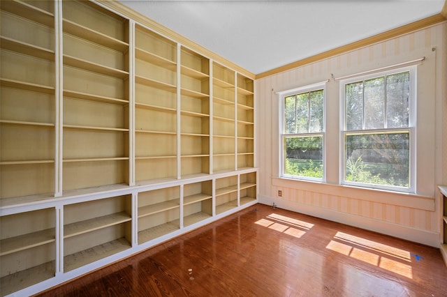 spare room featuring wood finished floors and ornamental molding