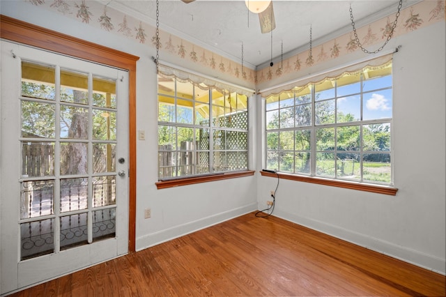 unfurnished sunroom featuring ceiling fan