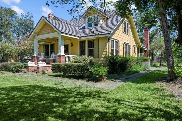 view of front of home with covered porch and a front lawn