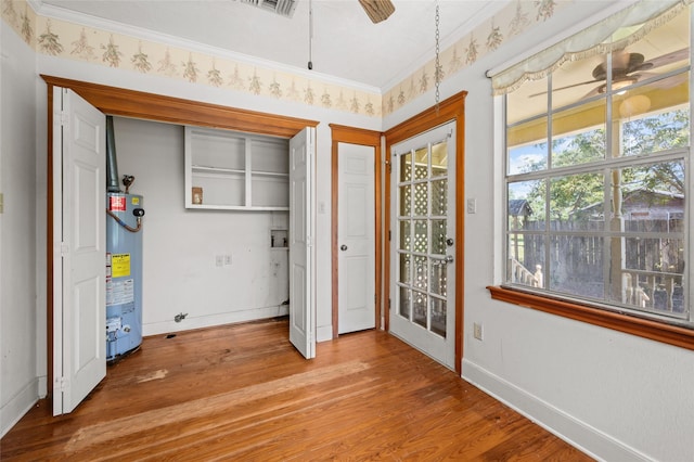 unfurnished bedroom with light wood-style flooring, baseboards, water heater, and ornamental molding