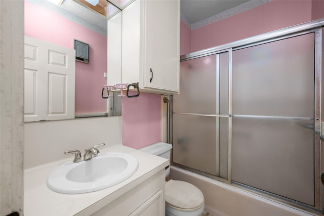 full bath with vanity, toilet, and combined bath / shower with glass door